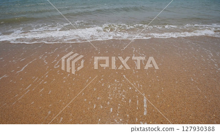 Soft wave gently washing golden sand on Crimean beach Soft wave gently washing golden sand on Crimean beach 127930388