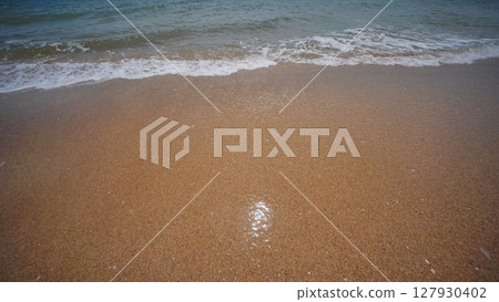 Gentle waves washing golden sand on Crimean beach Gentle waves washing golden sand on Crimean beach 127930402