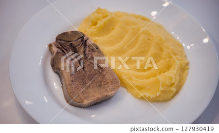 Boiled beef tongue served with mashed potatoes on white plate Boiled beef tongue served with mashed potatoes on white plate 127930419