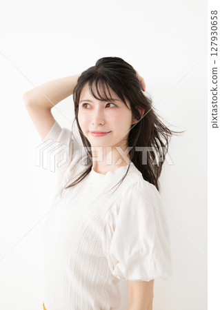 A woman touching her hair A woman touching her hair 127930658