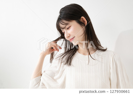 A woman touching her hair A woman touching her hair 127930661