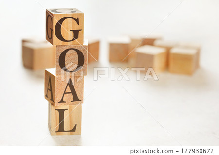 Four wooden cubes arranged in stack with word GOAL on them, space for text / image at down right corner 127930672
