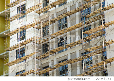 Scaffolding Against Modern Residential Building. Urban Development and Real Estate Business Growth Concept. 127931254