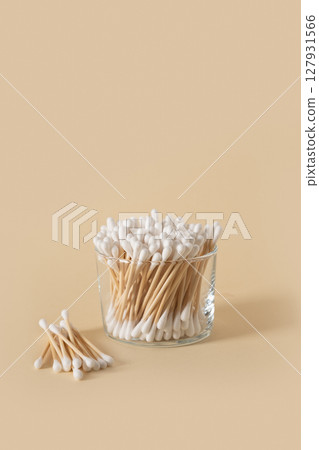 Wooden ecological cotton swab in glass jar on beige background. 127931566