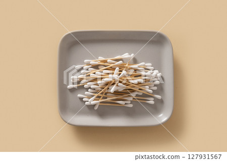 Wooden ecological cotton swab on beige background. 127931567