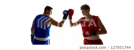 Boxers in red and blue gear touching gloves in sportsmanship gesture on white background Boxers in red and blue gear touching gloves in sportsmanship gesture on white background 127931744