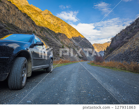 Car parked on gravel road in Kyrgyzstan mountainous region during daytime Car parked on gravel road in Kyrgyzstan mountainous region during daytime 127931863