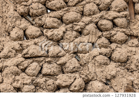 Rustic mud and stick balls wall in rural outdoor setting Rustic mud and stick balls wall in rural outdoor setting 127931928