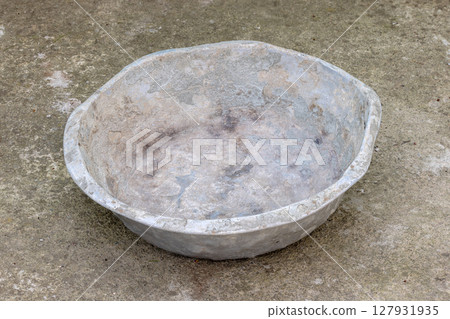 Weathered dented gray aluminum basin on concrete floor Weathered dented gray aluminum basin on concrete floor 127931935