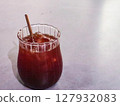 close up of a glass of iced americano with a eco friendly sugar cane straw with copy space on a white table 127932083