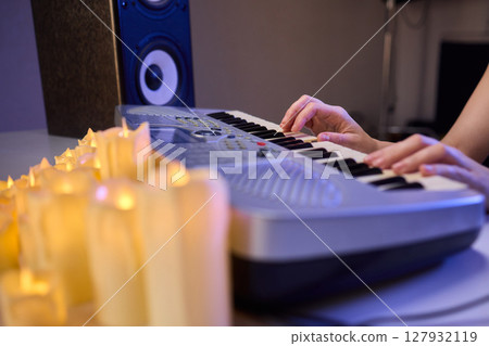 Hands play a keyboard in a modern studio, showcasing creativity and passion for music Hands play a keyboard in a modern studio, showcasing creativity and passion for music 127932119