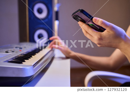 Hands play a keyboard in a modern studio, showcasing creativity and passion for music Hands play a keyboard in a modern studio, showcasing creativity and passion for music 127932120