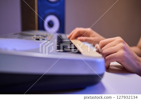 Hands play a keyboard in a modern studio, showcasing creativity and passion for music Hands play a keyboard in a modern studio, showcasing creativity and passion for music 127932134