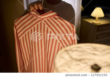 Delicate Dressing Preparing an Elegant Outfit in Soft, Cozy Lighting for Daily Wear and Style 127932193