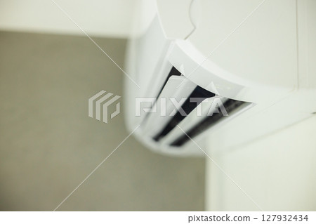 Close-up view of modern air conditioner vents with adjustable louvers, designed for efficient indoor air distribution and climate regulation. 127932434