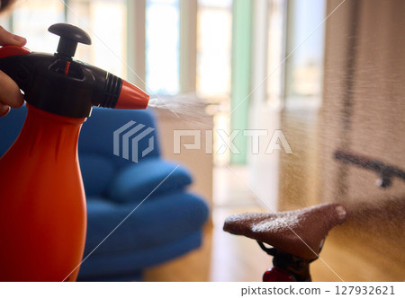 Engaging in Bicycle Cleaning with a Convenient Spray Bottle in a Cozy Environment Space 127932621
