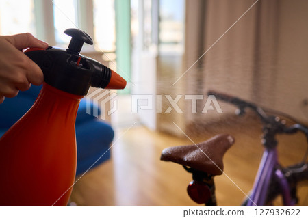 Engaging in Bicycle Cleaning with a Convenient Spray Bottle in a Cozy Environment Space 127932622