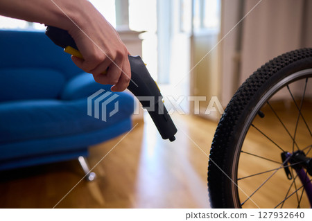 Effectively Cleaning a Bicycle Using a Vacuum Cleaner in a Contemporary Living Room Space Effectively Cleaning a Bicycle Using a Vacuum Cleaner in a Contemporary Living Room Space 127932640