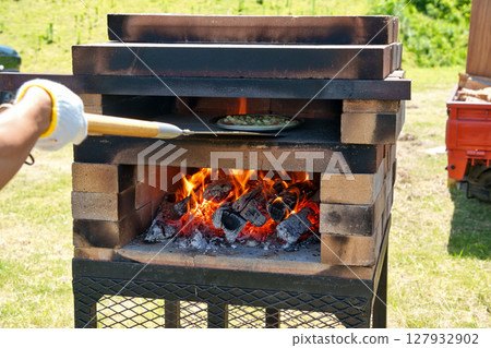 Bake pizza in a handmade brick pizza oven Bake pizza in a handmade brick pizza oven 127932902