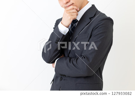 A middle-aged male businessman wearing a suit and worrying 127933082