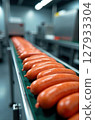 Sausages moving along conveyor belt in food processing plant 127933304