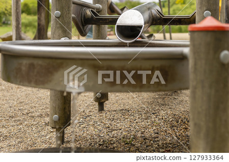 Kids can enjoy a fun and educational activity at a playground where water flows from a channel into a basin, providing an interactive experience with nature 127933364
