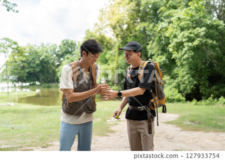 Father and Son Hiking Adventure. Two men enjoying nature while exploring a scenic trail. 127933754