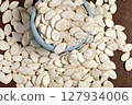 Large pumpkin seeds in a blue vase 127934006