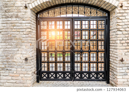 Beautiful medieval wooden gate with stone arch in old weathered building Beautiful medieval wooden gate with stone arch in old weathered building 127934063