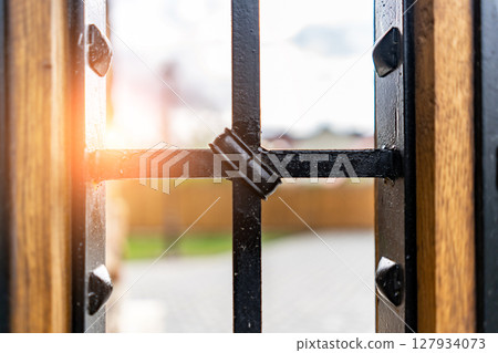 Selective focus, texture of a metal old lattice fence against the blue sky, fence lattice, lattice background, cell. High quality photo 127934073
