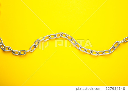 Iron chain of light metal on yellow background. 127934148