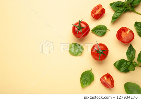 Cherry tomatoes and green basil on beige background Cherry tomatoes and green basil on beige background 127934176