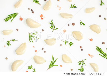 Fresh garlic cloves, peppercorns, rosemary and Himalayan salt scattered on a white background, top view food seasoning concept 127934318