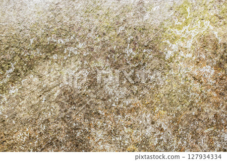 Close-up of a weathered mossy stone surface with natural earthy tones and rough texture, evoking age, decay, and organic patterns Close-up of a weathered mossy stone surface with natural earthy tones and rough texture, evoking age, decay, and organic patterns 127934334