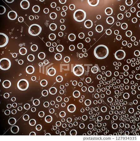 Close-up of carbonated bubbles rising in a fizzy brown beverage, creating a dynamic abstract pattern of circular shapes and light reflections Close-up of carbonated bubbles rising in a fizzy brown beverage, creating a dynamic abstract pattern of circular shapes and light reflections 127934335