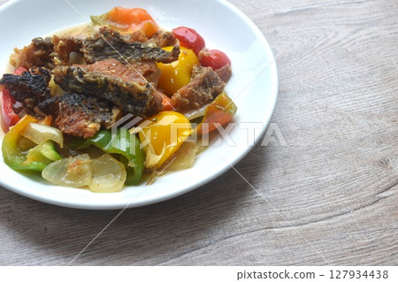 deep fried slice mango fish with bell pepper and onion in black pepper sauce on plate  127934438