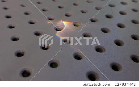 Rainbow sunny bunny atop dot pattern perforated surface 127934442