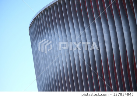 Cladding of a modern sports stadium against a blue sky Cladding of a modern sports stadium against a blue sky 127934945