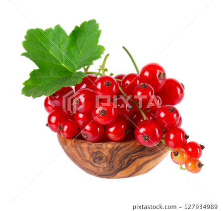 Red currant isolated on white background. Redcurrant or Ribes rubrum ripe berries with green leaves in wooden bowl. 127934989