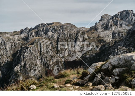 Towering peaks of Prokletije mountains in Montenegro country with jagged rock faces under dramatic overcast sky Towering peaks of Prokletije mountains in Montenegro country with jagged rock faces under dramatic overcast sky 127935091