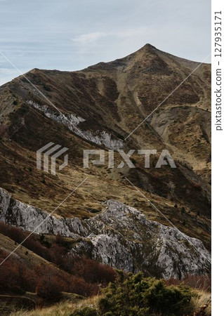 Sharp mountain peak and dry grassy slopes in Prokletije National Park, Montenegro, during fall season Sharp mountain peak and dry grassy slopes in Prokletije National Park, Montenegro, during fall season 127935171