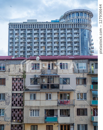 Batumi architecture concept. old house against the backdrop of a new high-rise building. Contrast in architecture. Housing for people Batumi architecture concept. old house against the backdrop of a new high-rise building. Contrast in architecture. Housing for people 127936644