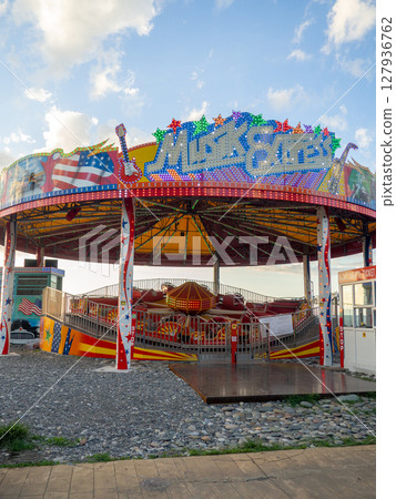 Amusement park. Entertainment concept. Carousel for children and adults. Thrilling sensations. Attraction on the sea coast Amusement park. Entertainment concept. Carousel for children and adults. Thrilling sensations. Attraction on the sea coast 127936762