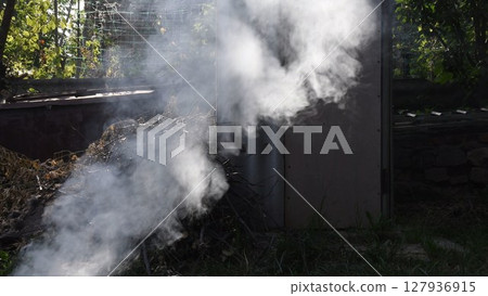 Smoke background outdoors over pile of dried branches firewood Smoke background outdoors over pile of dried branches firewood 127936915