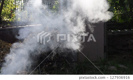 Smoke background outdoors over pile of dried branches firewood Smoke background outdoors over pile of dried branches firewood 127936916