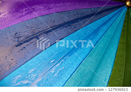 Raindrops on blue purple shades umbrella closeup wet fabric texture 127936923