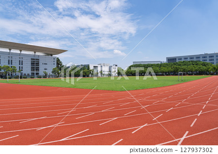 University campus football field and running track under blue sky and white clouds 127937302