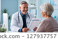 Doctor giving good news in examination room 127937757