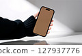 closeup image of male hand holding smartphone 127937776