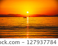 Sunset over the sea and small boats 127937784